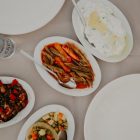 Top view of various delicious food on table with dishware and silverware in restaurant on daytime